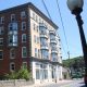 An apartment building facade with 6 floors at the street front on a sunny day.